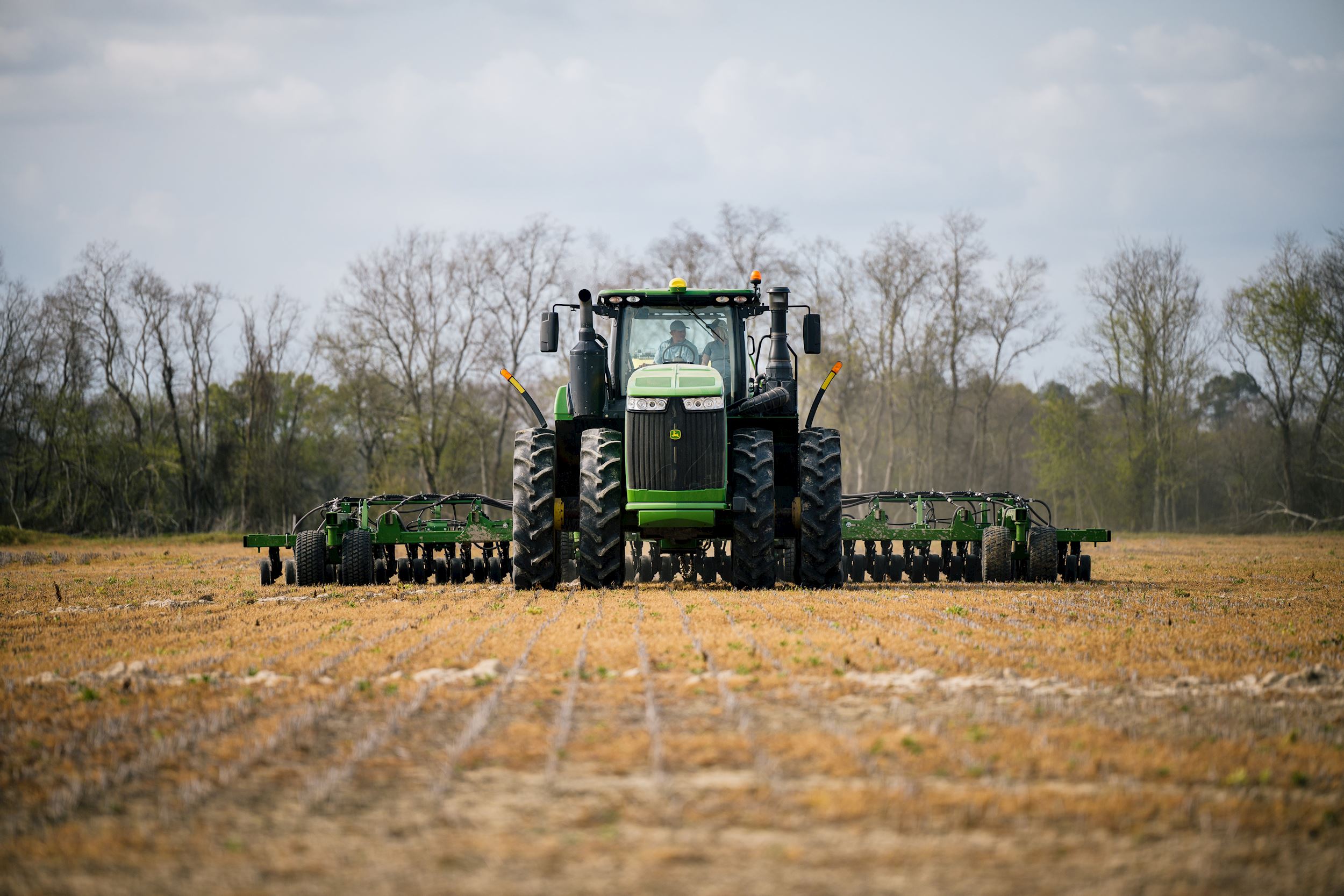 man plants rice with a John Deere tractor and drill 